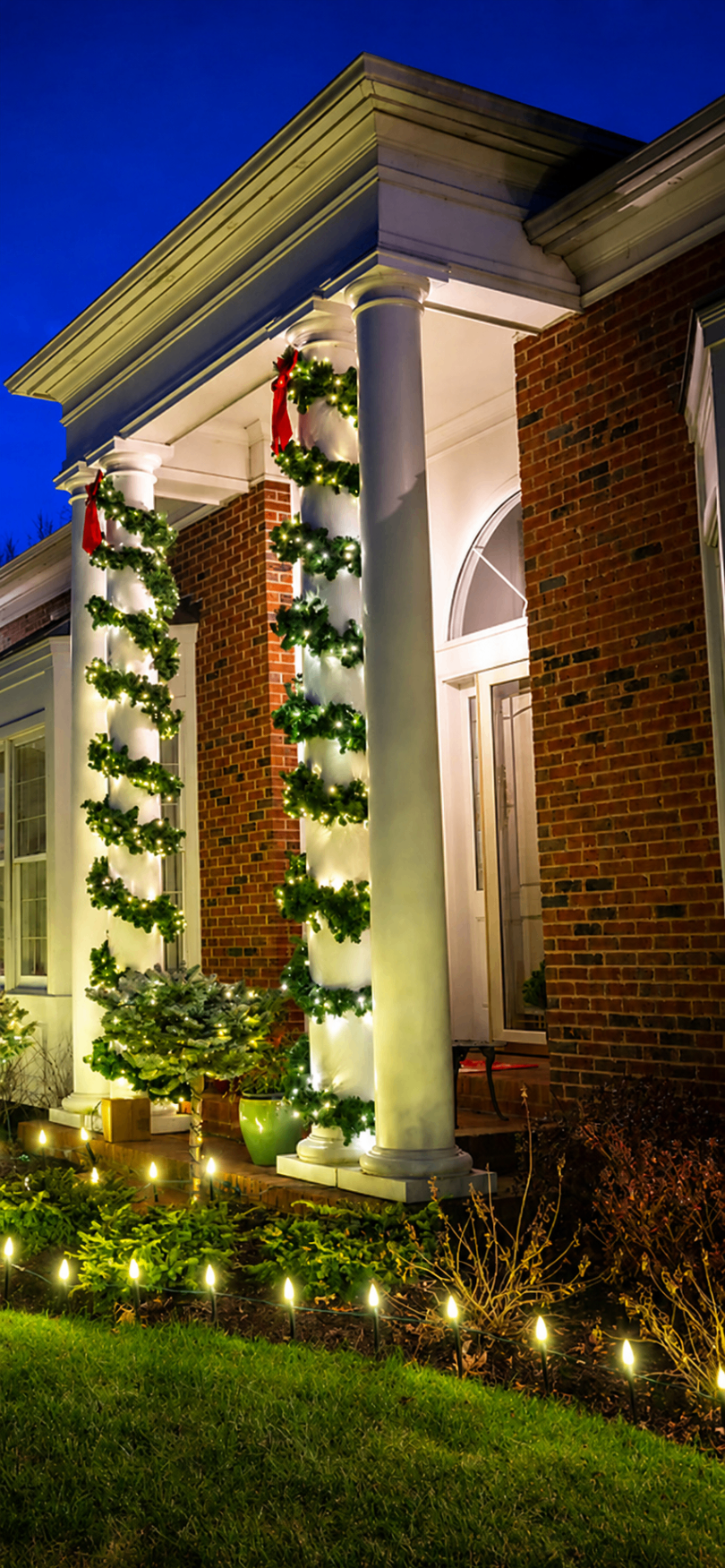 Richmond Heights porch with glowing garland wrapped around white columns