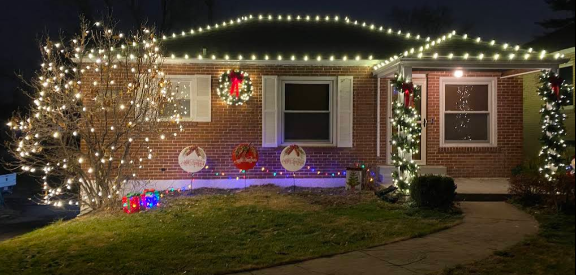 Brick ranch home with warm white Christmas lighting