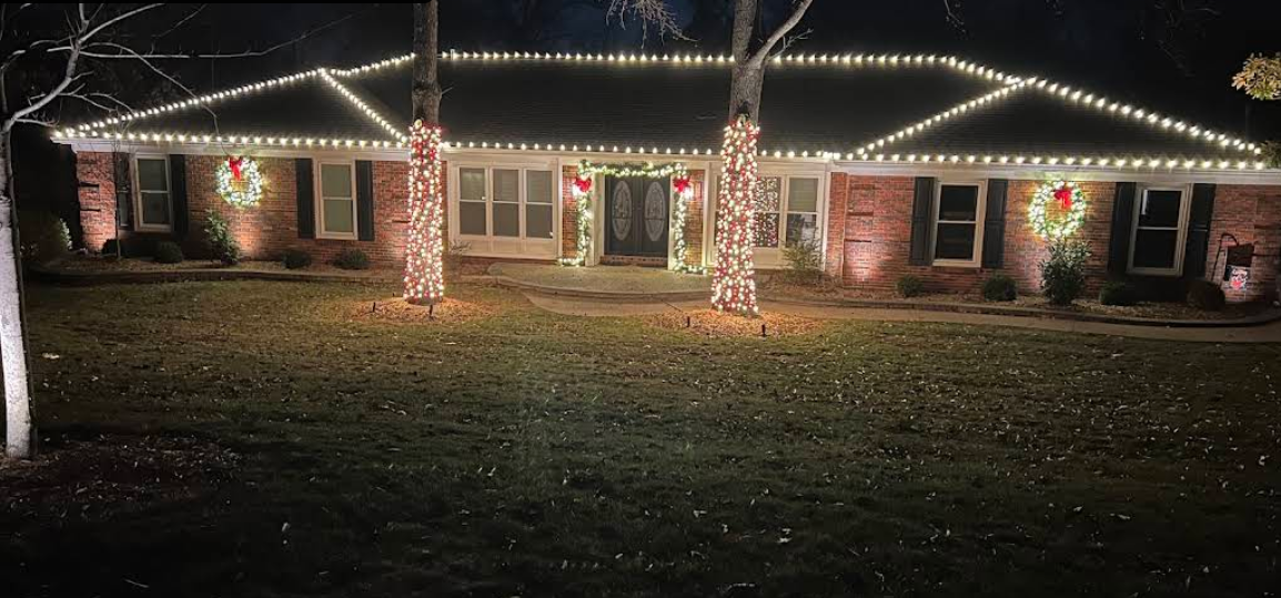 Warm white Christmas lights along a brick home roofline
